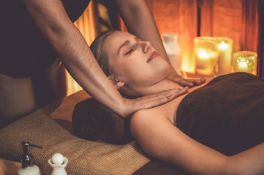 Beyaz kadın müşteri stres önleyici spa masajının keyfini çıkarıyor ve lüks otel ya da otelde sıcak mum ışığında güzellik teniyle eğleniyor. Sessiz.