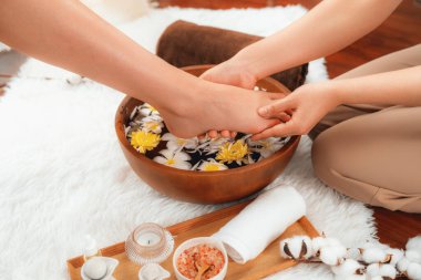 Kadınlar lüks spa salonlarında keyifli ayak masajlarına devam ederken, masör de hafif gün ışığı atmosferinde refleksoloji terapisi veya otel ayak spa 'sında. Sessiz.