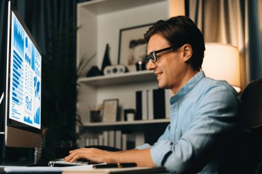 Akıllı iş adamı iş paragrafı dinamik pazarlama analizi planını analiz ediyor. Kağıt kağıtları ve bilgisayar monitörü raporlarını gece evdeki belge verileriyle karşılaştırmak için hazırlıyor. Bireysel.