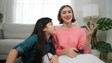 Mutlu çocuk oyun oynuyor ve oturma odasında otururken annesini kazanıyor. Çekici kız elini havaya kaldırıp şarapları kutlarken beyaz bir anneyle vakit geçiriyor. Pedagoji.