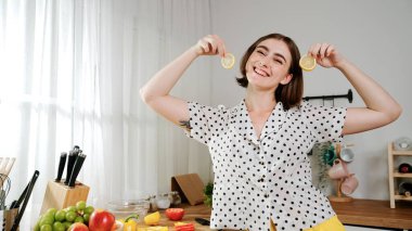 Mutlu anne sebze doğruyor ya da salata yapıp kameraya poz veriyor. Evin bekçisi kameraya bakarken taze malzemeler hazırlar. Modern mutfakta mutfak gereçleriyle yemek pişiren zeki bir anne. Pedagoji.