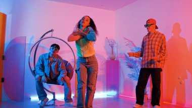 Çekici mutlu dansçı kameraya bakarken zeki kadın neon ışıkla kafiyeli hareket ediyor. Profesyonel İspanyol şarkıcı çeşitli arkadaşlarıyla renkli kıyafetler giyerken break dans yapıyor. Mutluluk.