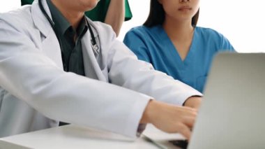 Hastane masasında birlikte çalışan ve tıbbi tedavi planlayan çeşitli profesyonel sağlık görevlileri. Takım çalışması başarılı hastalıklara ve hastalıklara yol açar. Ağır çekim. Katı.