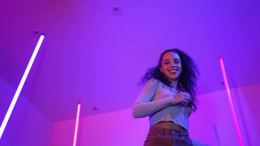 Latin dansçıların kameraya bakıp şehrin pop müziğiyle dans ettiği düşük açılı kamera. Profesyonel çekici hipster, mor veya neon ışıklı hip hop şarkısına geçiyor. Şık bir kumaş. Mutluluk.