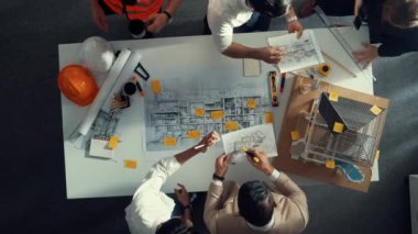 Becerikli mühendis ekibinin ev inşaatından bahsedişinin en alt görüntüsü. Mimar ya da tasarımcı grubunun planlar hakkında beyin fırtınası yapmak için tartışan ve yazan hava görüşü. Hizalama.