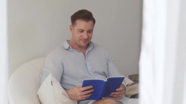 Kanepede oturan orta yaşlı bir adam, sosyal ve teknolojik mesleki gelişmeler hakkında ders kitabı okur ya da çocukları iyi bir yetişkin baba olmak için yetiştirir. Hayat boyu öğrenme konsepti. Uyumsuzluk.