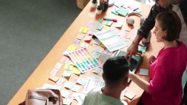 İşadamı logosu grafiği çizerken proje yöneticisinin birlikte çalışıp renk paletlerine bakarak beyin fırtınası yapma fikrini kapatın. Rengi birlikte seçen profesyonel bir iş adamı. Sempozyum.