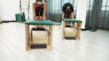 Müşteriler pilates antrenmanı sırasında ayakta gerinme egzersizi yapıyorlar. Esnekliği artırmak için. Spor salonunda bacak dayanıklılığı. Çekici grup esniyor ve eğiliyor. Alışkanlık.