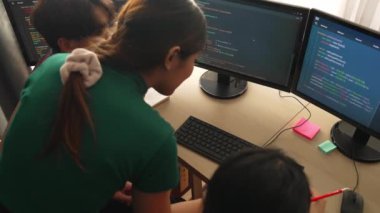 Yavaş çekim arkası yazılım geliştirici mühendisi bilgisayar programlama için birlikte çalışarak hata ayıklama kodunu çözüyor, ofiste monitörde karmaşık algoritmaları çözüyor. Filizlenen