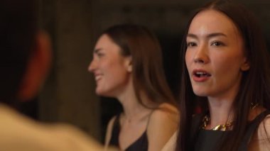 Lüks bir kokteyl barında grup arkadaşıyla gülümseyen güzel bir kadının portresi. Gece kulübünde sosyetik etkileşim için doğal yüz güzelliğini kostüm içinde yakalamak. Vinosity.