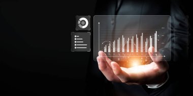 İş adamı, tahmin edilen büyük veri modellerinden gerçek zamanlı analizlere uzanan eğilimleri ve görüşleri ortaya çıkarmak için veri analizlerini derinlemesine inceleyerek, veri güdümlü kararların analitik endüstrileri nasıl ileri götürdüğünü öğrenir Faas