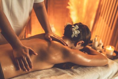 Beyaz kadın müşteri stres önleyici spa masajının keyfini çıkarıyor ve lüks otel ya da otelde sıcak mum ışığında güzellik teniyle eğleniyor. Sessiz.