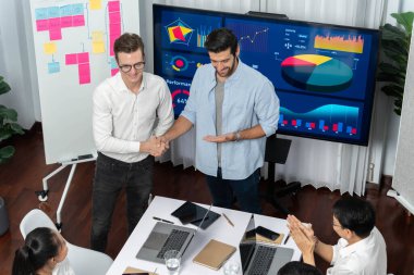 Analist ekip lideri, iş zekası ya da BI gösterge paneli ile FIntech yazılım gücünü kullanarak başarılı veri analizi toplantısından sonra iş arkadaşıyla tokalaştı. Tedbirli