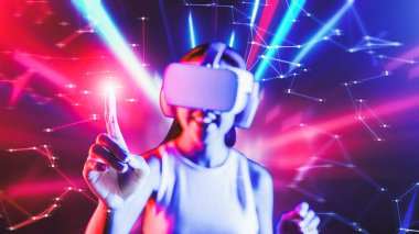 Zeki bir kadın, metaevreni birbirine bağlayan VR kulaklık takan neon ışıklarla çevrili duruyor. Gelecekteki siber uzay topluluğu teknolojisi. Sanal objeye parmağını kullanan zarif bir kadın. Halüsinasyon.