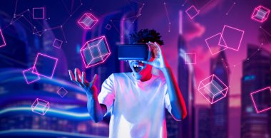 Afrikalı adam metaevrende oyun oynarken heyecanlı ve şekle bakıyor. Gündelik kıyafet öğrenme ve geleceğe dönük şehirde havada süzülen şekle bakma yeteneği olan zeki bir oyuncu. Teknoloji. Yaratıcılık.