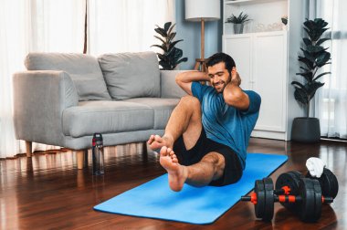 Atletik ve sporcu adam, evde vücut egzersizi yaparken spor ve spor yaşam tarzına uyum sağlamak için spor minderinde çatırdıyor. Gaiety ev egzersizi antrenman konsepti.