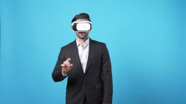 Yetenekli bir iş adamı mavi arka planda dururken hologramı tutuyor. Proje yöneticisi artırılmış gerçeklik teknolojisi kullanarak pazarlama stratejisi planlarken mali raporları kontrol ediyor. Aygıt.