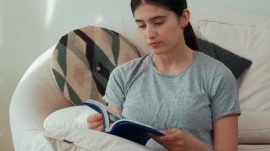 Kanepede oturan orta yaşlı bir kadın, sosyal ve teknolojik mesleki gelişmeler hakkında ders kitabı okur ya da zeki bir anne olmak için çocuk yetiştirir. Hayat boyu öğrenme konsepti. Uyumsuzluk.