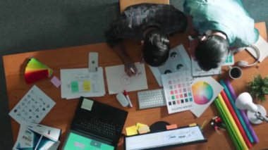 Profesyonel tasarımcının renkli paletten renk seçmesine yardımcı olması zaman aşımı. Dizüstü bilgisayardan logoya bakarken birlikte çalışan ve planlayan iş adamlarının hava görüntüsü. Sempozyum.