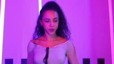 Stüdyoda mor ışıkla sokak dansı yapan İspanyol sokak dansçılarına yakın çekim. Profesyonel sanatçı şık kumaşla enerjik bir hareket sergiler. Çılgın, komik. Yarı vücut. Mutluluk.