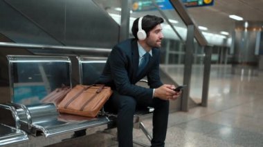 Tren istasyonunda oturmuş müzik dinleyen yetenekli bir iş adamı. Profesyonel Kafkas proje yöneticisi tren ya da metro bekliyor. Erkek lider dinlemekten hoşlanır. Takım elbiseli rahat müzik. Sevinçli..