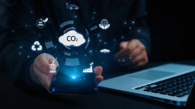 İş adamı CO2 emisyonlarını azaltmak için girişimlerde bulunuyor ve net sıfır hedefliyor. Daha yeşil bir gezegenin karbondioksitini azaltarak sürdürülebilirliğe olan bağlılığını gösteriyor. Kullanıcı Kimliği