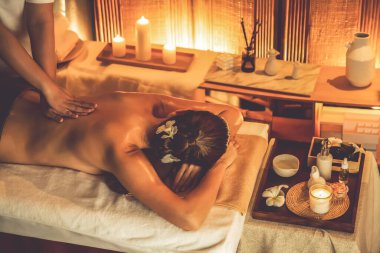 Beyaz kadın müşteri stres önleyici spa masajının keyfini çıkarıyor ve lüks otel ya da otelde sıcak mum ışığında güzellik teniyle eğleniyor. Sessiz.