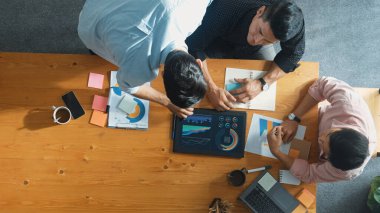 Yönetici, toplantı odasındaki meslektaşlarına mali grafiği açıklar. Farklı pazarlama ekibinin tabletle masada otururken fikir ve planlama stratejisini en üst düzeyde paylaşması. Cemaat.