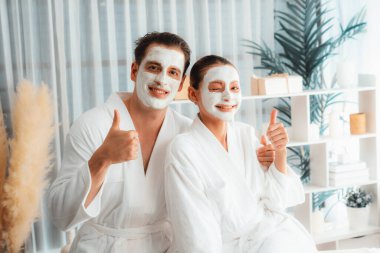 Yüzü kremli, bornozlu mutlu bir çift tatil boyunca kaplıca salonu ya da otelin huzurlu atmosferinin tadını çıkarıyor. Şımarık yüz spa 'sı ve cilt bakımı, esans rahatlığı. Sessiz.