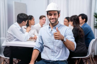 Mühendis ekip lideri portresi çeşitli inşaat mühendisi ve müvekkil gruplarıyla birlikte mimari proje üzerinde çalışıyor, inşaat planını gözden geçiriyor ve toplantı masasında proje oluşturuyorlar. Tedbirli