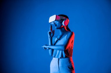 VR kulaklık takan zeki bir kadın metaevrene bağlanıyor, gelecekteki siber uzay topluluğu teknolojisi. Sanal silaha hükmeden zarif bir kadın ciddi ciddi oyun oynuyor. Halüsinasyon.