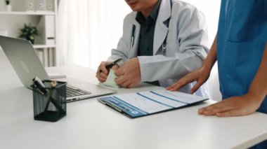 Hastane masasında birlikte çalışan ve tıbbi tedavi planlayan çeşitli profesyonel sağlık görevlileri. Takım çalışması başarılı hastalıklara ve hastalıklara yol açar. Ağır çekim. Katı.