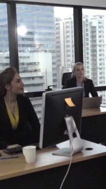 Kıdemli lider takım üyelerine tavsiye konuşması yapıyor. Modern ofisteki masada yaratıcı iş adamları buluşuyor. Çok kültürlü iş ekibi..