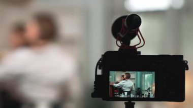Arka görünüm, kamera ekranının arkasında iki kadın nüfuzlu görüntüleyicinin video görüntülerini, video görüntülerini, kıyafetleri, sosyal medyayı ya da blogu görüntülemesini gizler. Canlı yayın için stüdyo ışıklandırmalı kızlar canlı yayın pazarlama kayıt oturumu