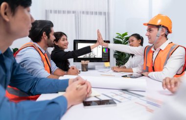 Çeşitli inşaat mühendisi ve müvekkil grupları, mimari proje üzerinde başarılı bir anlaşma yaptıktan, inşaat planını gözden geçirdikten ve toplantı masasında plan oluşturduktan sonra kutlama ve beşlik çakışma yaptılar.