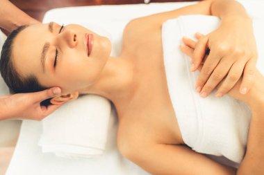 Kafkasyalı kadın stres önleyici kafa masajından ve lüks tatil beldesi ya da otel spa salonundaki modern ışık ortamında yüz güzelliği eğlencelerini şımartmaktan hoşlanıyor. Sessiz.