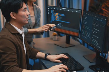 Bilgi teknolojisi geliştiricileri modern ofisteki neon ışık odasında verileri çevrimiçi olarak çalıştıran akıllı web sitesi geliştirme kodlayıcı sistemine işaret ediyorlar. İnfobahn.