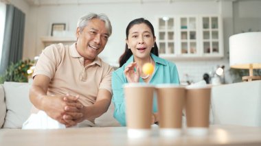 Mutlu yaşlı çift evde birlikte top atmaktan zevk alıyor, sağlıklı yaşlanma için koordinasyon ve bilişsel beceriler geliştiriyorlar. Büyükbabam ve büyükannem klozete pinpon oynuyorlar. Myrmidon.