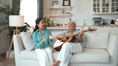 Karısı şarkı söyleyip müzik yaparken, kanepede oturup gitar ya da müzik aleti çalan mutlu bir adam. Yaşlı çift birlikte vakit geçiriyor ve birlikte eğleniyorlar. Myrmidon.