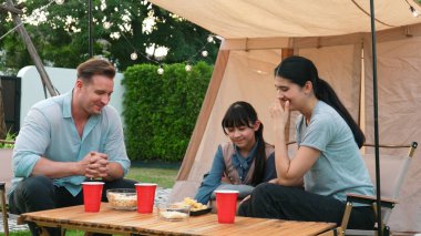 Family all together sit at camp in garden with tasty snack. Lovely parent use outdoor camping activity as way to communicate and spending time with young generation cross generation gap. Divergence. clipart