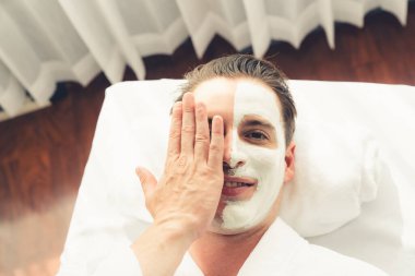 Kaplıca salonunun sakin atmosferi, insan müşterisi modern gün ışığında lüks yüz kremi masajıyla kendini yenileme zevkine kapılıyor. Yüz bakımı ve güzellik konsepti. Sessiz.