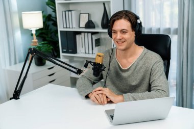 Sunucu kanalı, gülümseyen akıllı yayıncı kaydı, senaryosu ve akıllı telefonuyla sosyal medyada sohbet programı, kulaklık takarak modern ev stüdyosundaki video flamalarını kaydediyor. Bireysel.