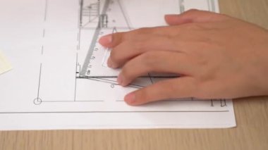 Akıllı mimar ya da akıllı mühendisin ölçüm aracı ve el yazısı tasarımı kullanarak mimari ofisteki inşaat doğruluğu için ayrıntılı bir tasarım videosu. Eline odaklan. - Yakın çekim. Tanımlama.