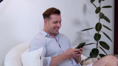 Orta yaşlı bir adam oturma odasındaki koltukta oturur telefon arama verilerini kullanır çocukları iyi bir yetişkin baba ya da eğlence olarak yetiştirir. İşadamı teknolojiyi kolaylık için kullanır. Uyumsuzluk.