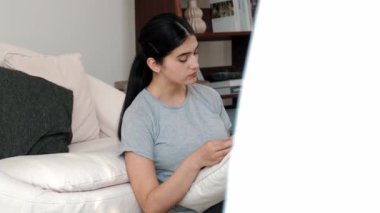 Kanepede oturan bir kadın ders kitabı okuyarak sosyal ve mesleki teknoloji bilgisini artırır ya da akıllı bir anne olmak için çocuk yetiştirir. Hayat boyu öğrenme konsepti. Uyumsuzluk.