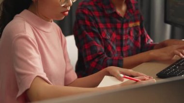 Yavaş çekim arkası yazılım geliştirici mühendisi bilgisayar programlama için birlikte çalışarak hata ayıklama kodunu çözüyor, ofiste monitörde karmaşık algoritmaları çözüyor. Filizlenen