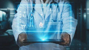 Doktorun laboratuvarda bulanık bir geçmişi olan insan anatomisi hologramı içeren tablet göndermesini kapatın. Sağlık çalışanı tableti tutuyor ve bütün gövdeyi kontrol ediyor. Teknoloji. İyileştirici.