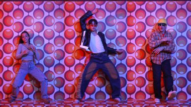 Parti sahnesinde kameraya bakarken balon geçmişiyle birlikte dans eden mutlu çok kültürlü dansçılar. Zeki hipster grubu müzik yapıyor ve sokak dansı yapıyor. Tam vücut. Mutluluk.