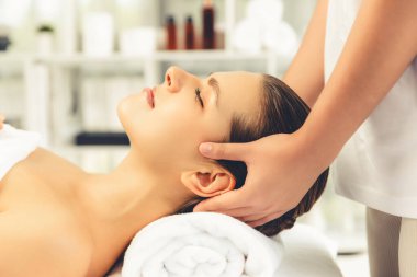 Kafkasyalı kadın stres önleyici kafa masajından ve lüks tatil beldesi ya da otel spa salonundaki modern ışık ortamında yüz güzelliği eğlencelerini şımartmaktan hoşlanıyor. Sessiz.