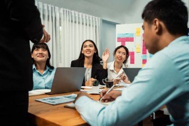 Çeşitli etnik analist grupları aktif olarak iş toplantılarına katılıyor, uzmanlıklarını ellerini kaldırarak gösteriyorlar ve televizyon ekranı veri analizi paneli ile ilgili anlayışlı sorular soruyorlar. Habiliment